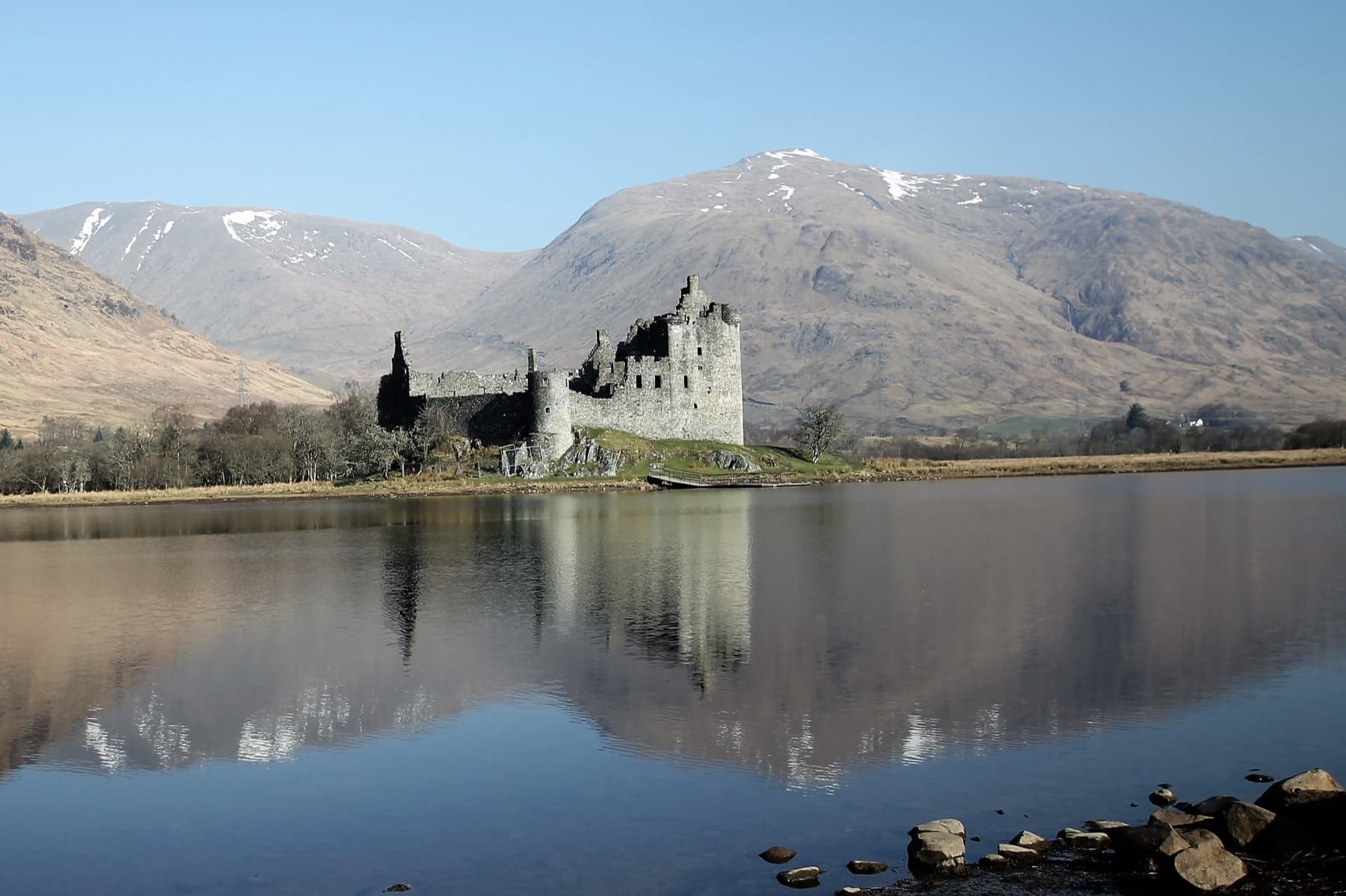 Kilchurn Castle beside a loch with mountains behind it